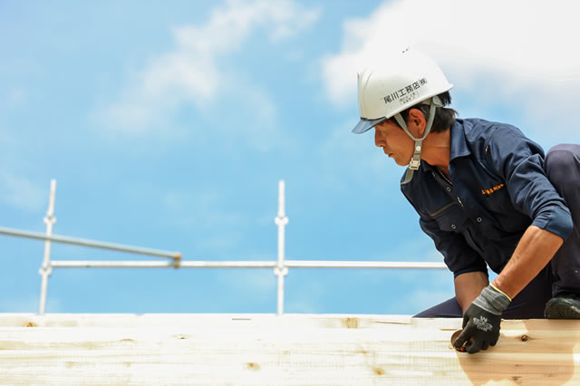 尾川工務店のヘルメットをつけた職人が作業をしている様子
